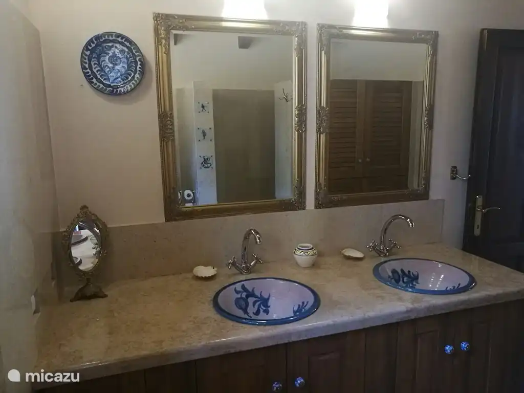 El baño es grande con un lavabo doble y una amplia ducha a ras de suelo.