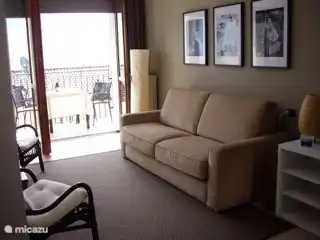 Desde la sala de estar con sofá cama tiene una gran vista sobre el lago. Las amplias puertas francesas dan acceso al soleado balcón.