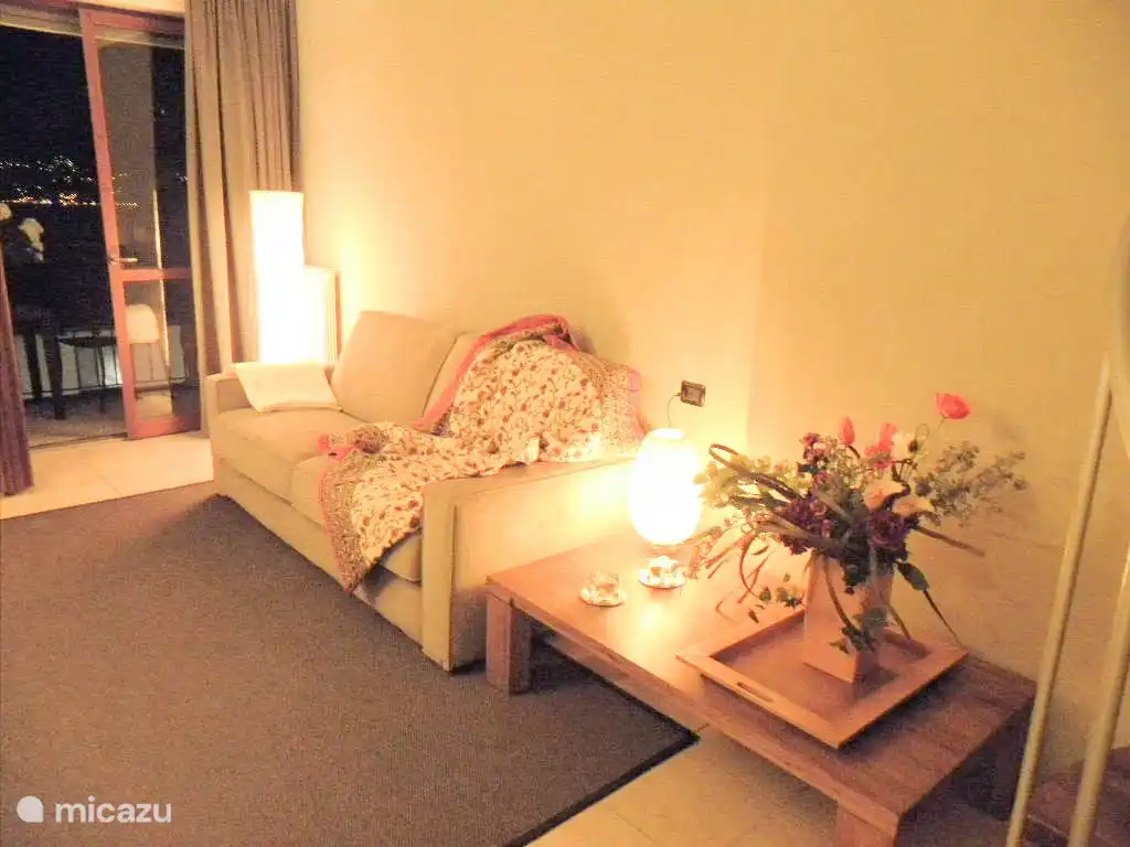 La sala de estar está atractivamente iluminada por la noche. La vista sobre el lago también es muy especial.