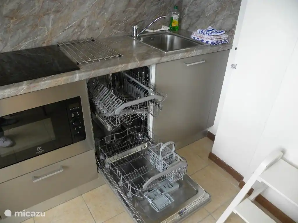 La cocina abierta está totalmente equipada con grill/microondas, lavavajillas, placa de inducción, cafetera, tetera y suficientes utensilios de cocina, cubertería y vajilla.