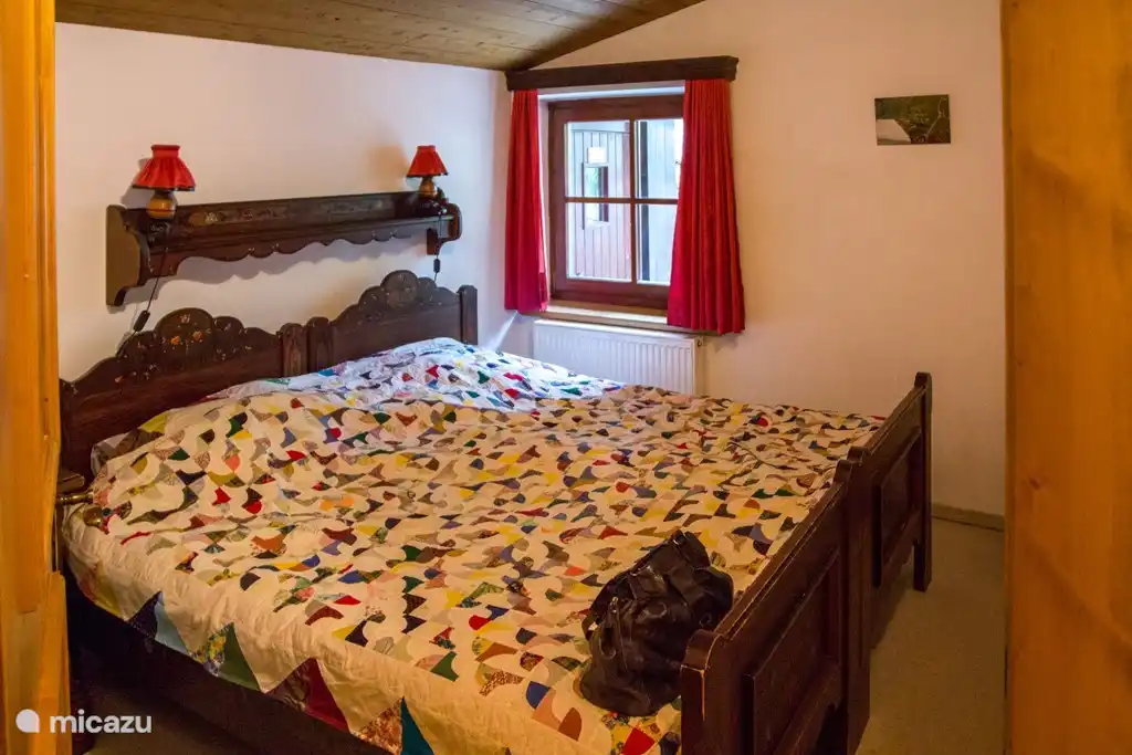 ...de 1e slaapkamer in Tiroler stijl met tweepersoonsbed...