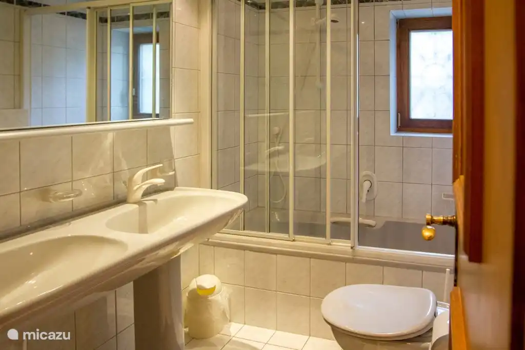 ...de tweede badkamer met bad, douche, toilet en dubbele wastafel...