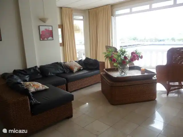 Location de Vacances Curaçao, Curaçao-Centre, Willemstad, appartement - Appartement Pontjesbrug Curaçao Ce salon avec façade entièrement ouvrante donne également accès au balcon de la chambre côté port / mer, un endroit merveilleux pour prendre le petit déjeuner et regarder les navires entrer. Le salon dispose également d'une table à manger avec 4 chaises.