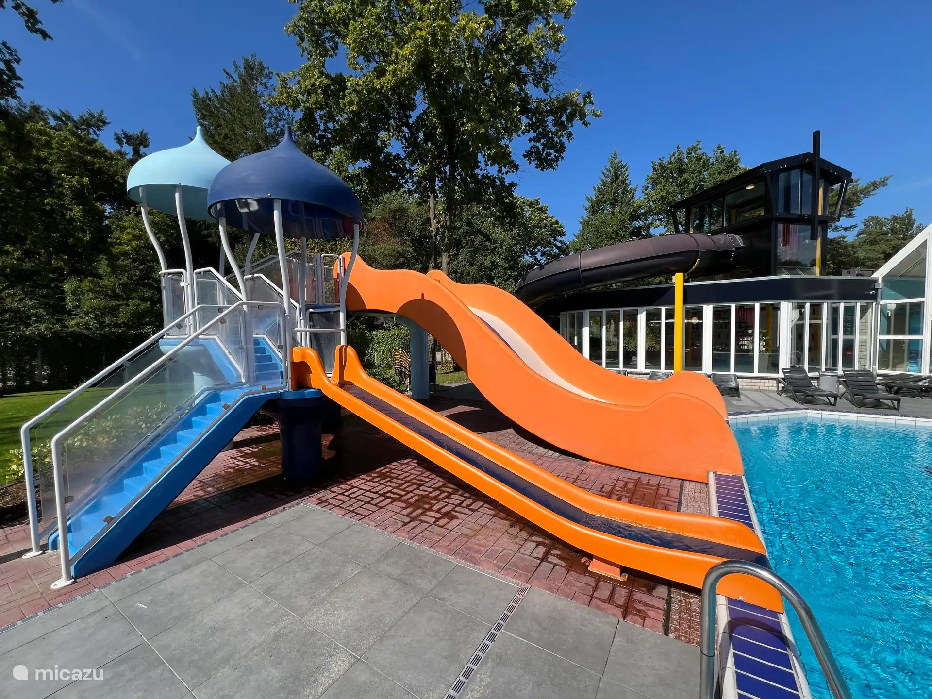 Outdoor-Rutschen im Vordergrund, Indoor-Rutsche mit Lichteffekt im Hintergrund.