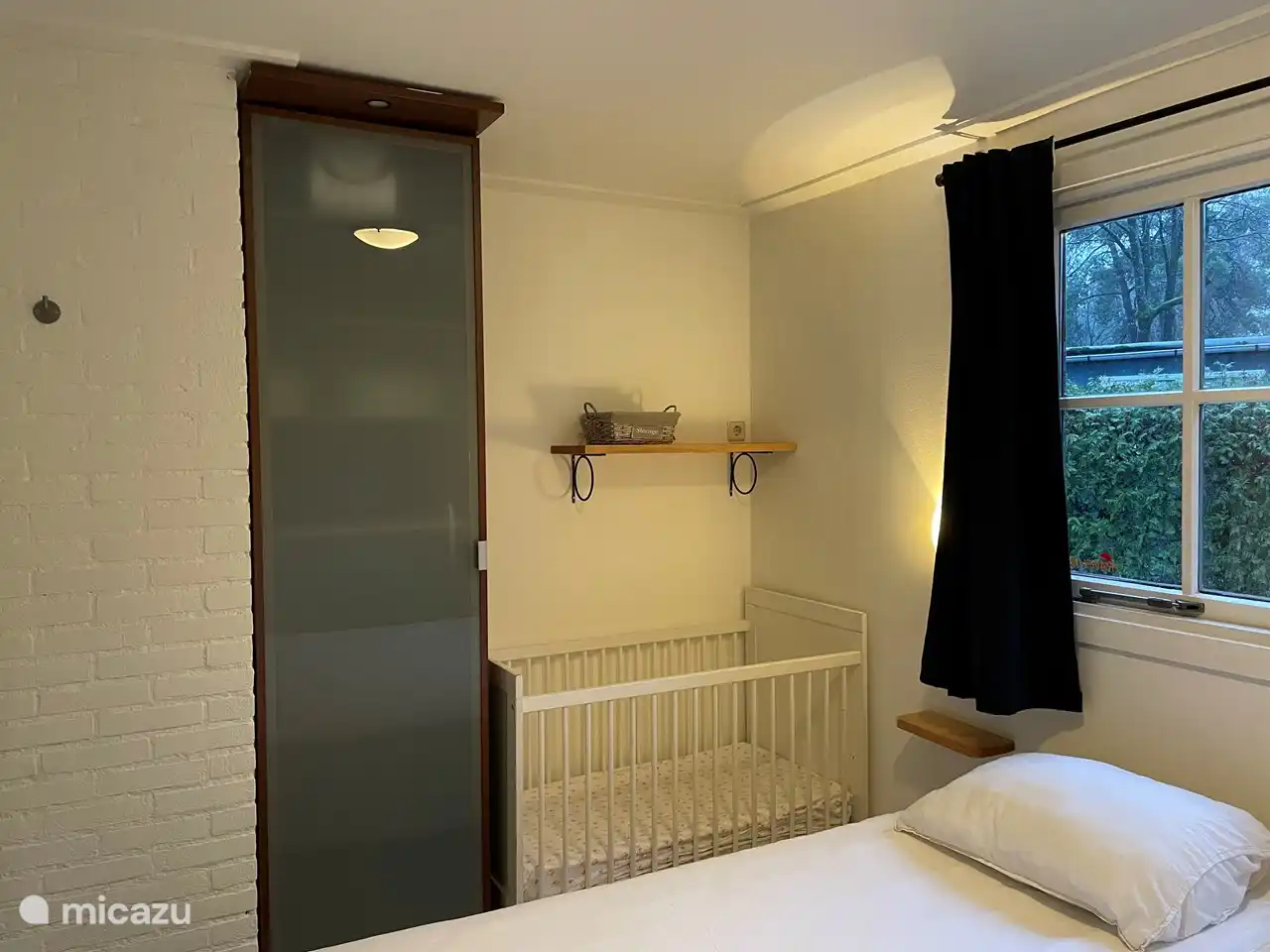 Das Hauptschlafzimmer ist praktischerweise mit einem Kinderbett ausgestattet.