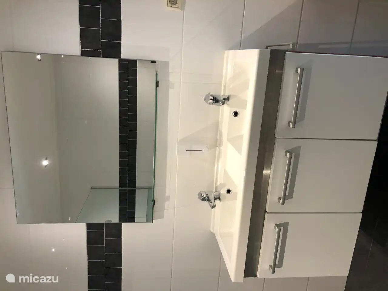 Doppelwaschbecken mit großem Spiegel und viel Stauraum unter der Spüle.