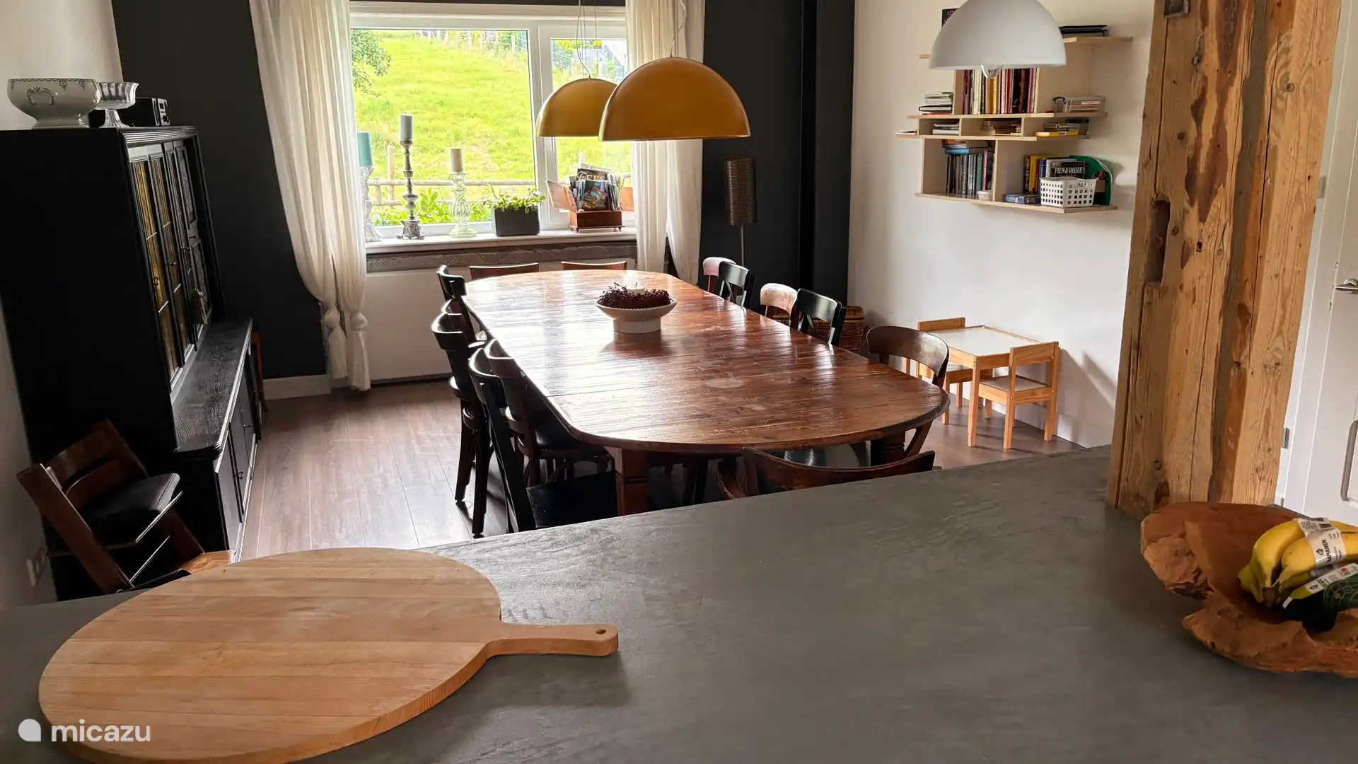 Gran mesa de comedor donde 14 personas pueden encontrar f&#225;cilmente un lugar.