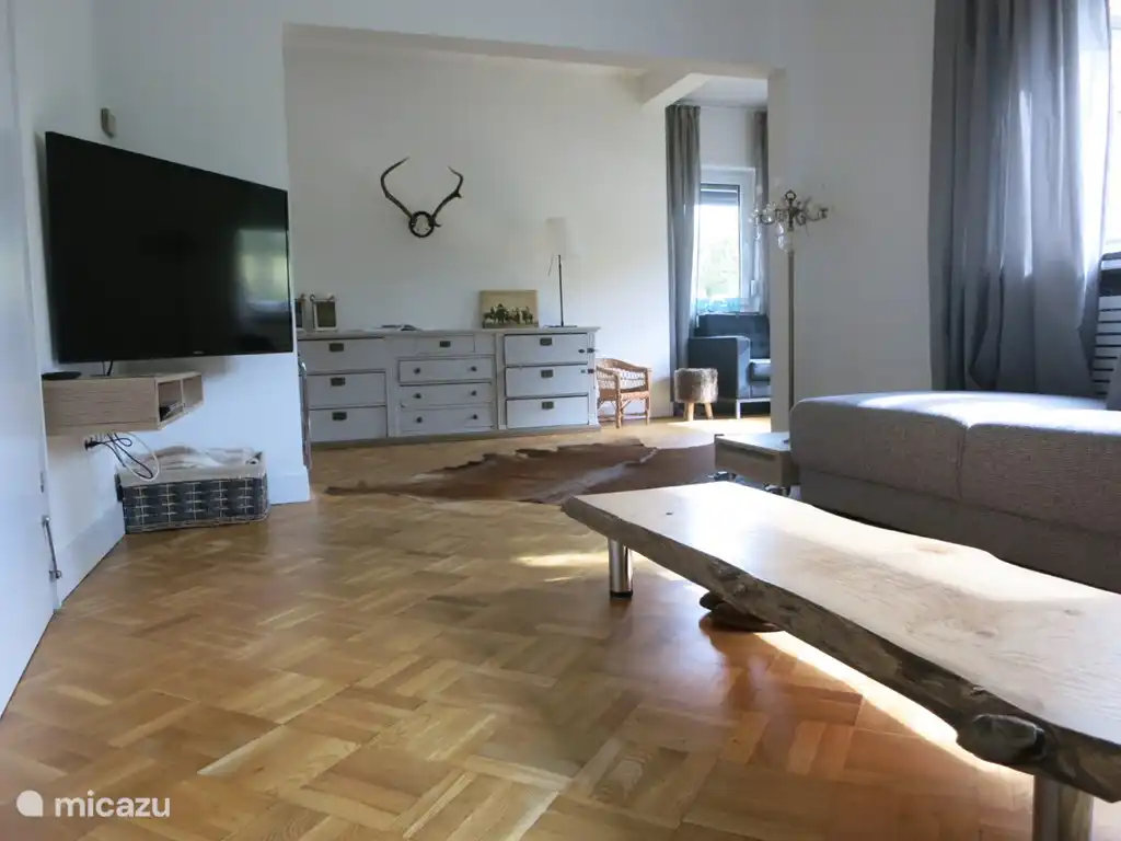 Hay una amplia sala de estar independiente con TV, un gran sof&#225; esquinero y asientos separados en el ventanal.