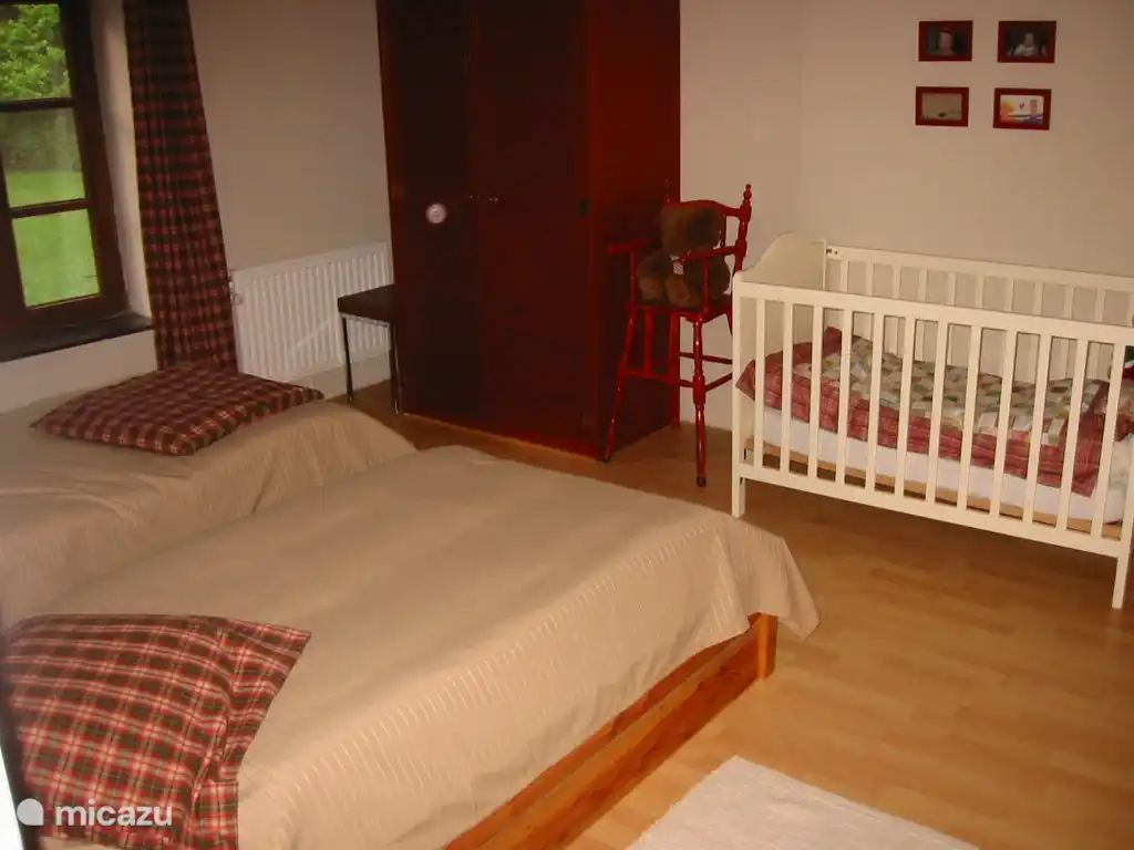 Dormitorio al frente con dos camas individuales y una cuna