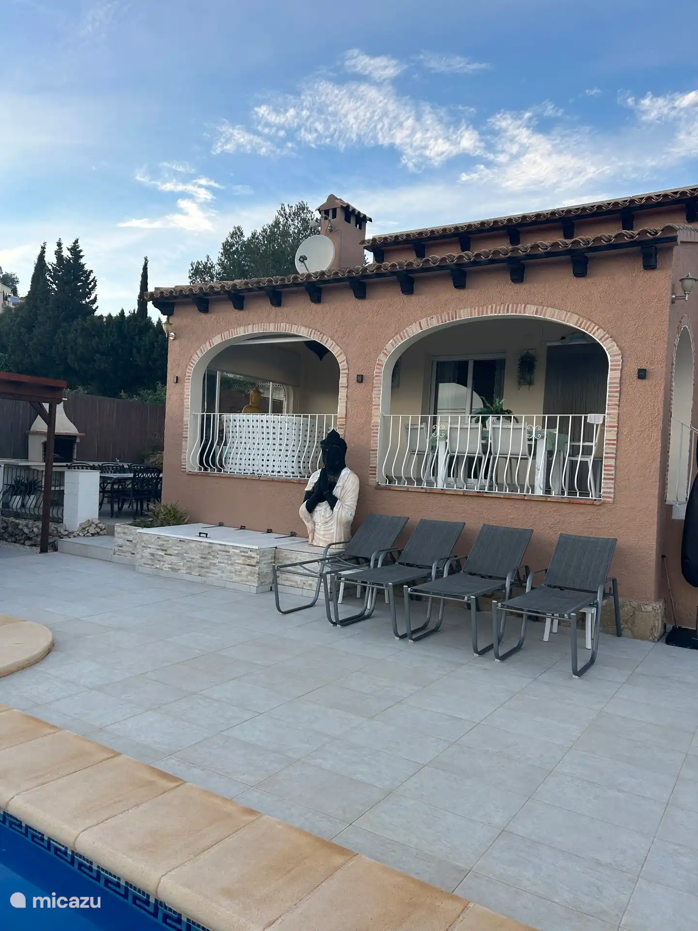 La belle grande terrasse ensoleillée au bord de la piscine 