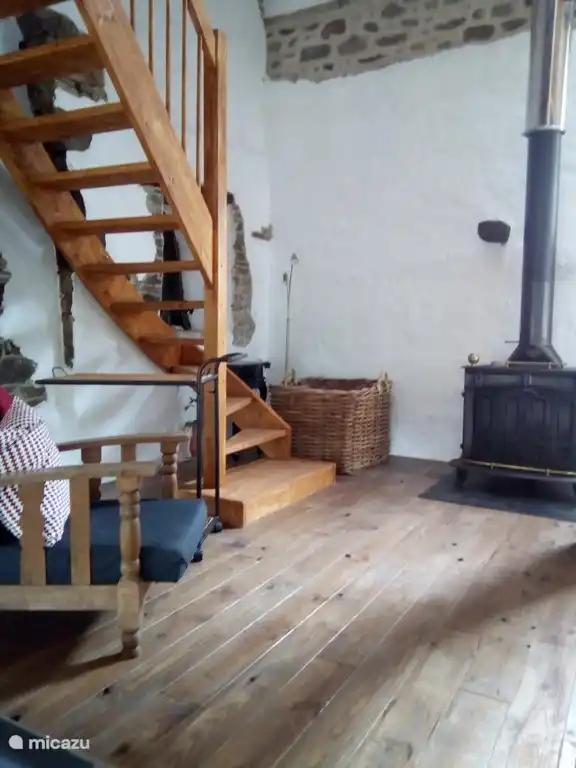 Woonkamer met trap naar boven en houtkachel