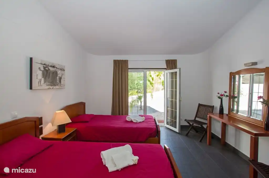 Zweites Schlafzimmer mit Französisch Fenster und zwei Einzelbetten.