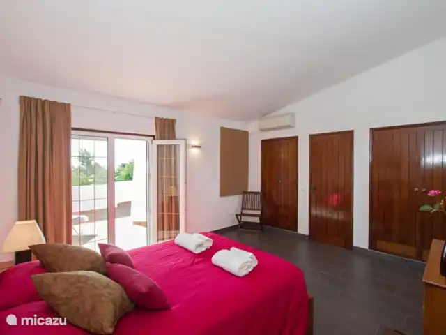 Casa comme Videiras | Portugal, Algarve, Carvoeiro - villa Chambre 4 avec portes-fenêtres donnant sur la terrasse sur le toit. C'est en fait la plus belle chambre de la maison, car depuis la terrasse sur le toit, vous avez une belle vue sur les environs et pouvez même voir la mer au loin.