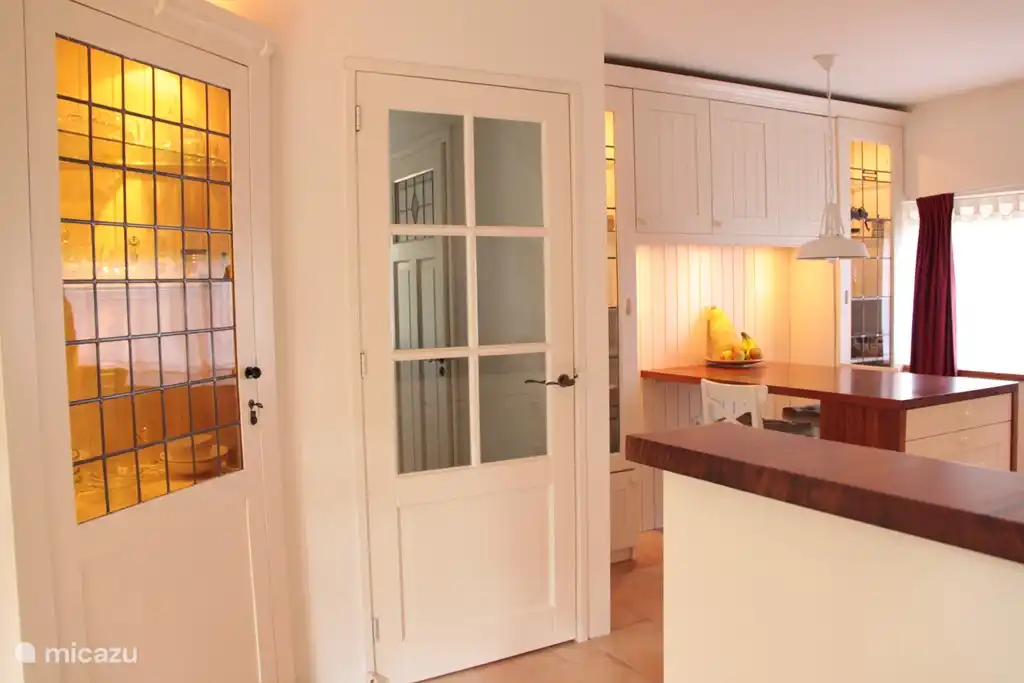 Umfangreiche Frühstück in der warmen Landhausküche mit Glasvitrinen.