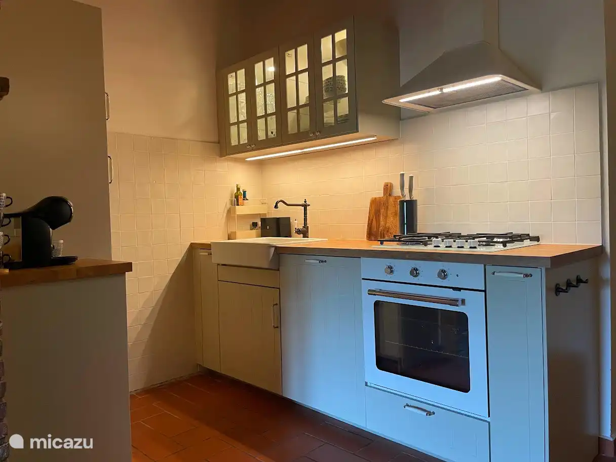 Voll ausgestattete Küche mit Ofen, Herd, Geschirrspüler und Kühlschrank-Gefrierfach.