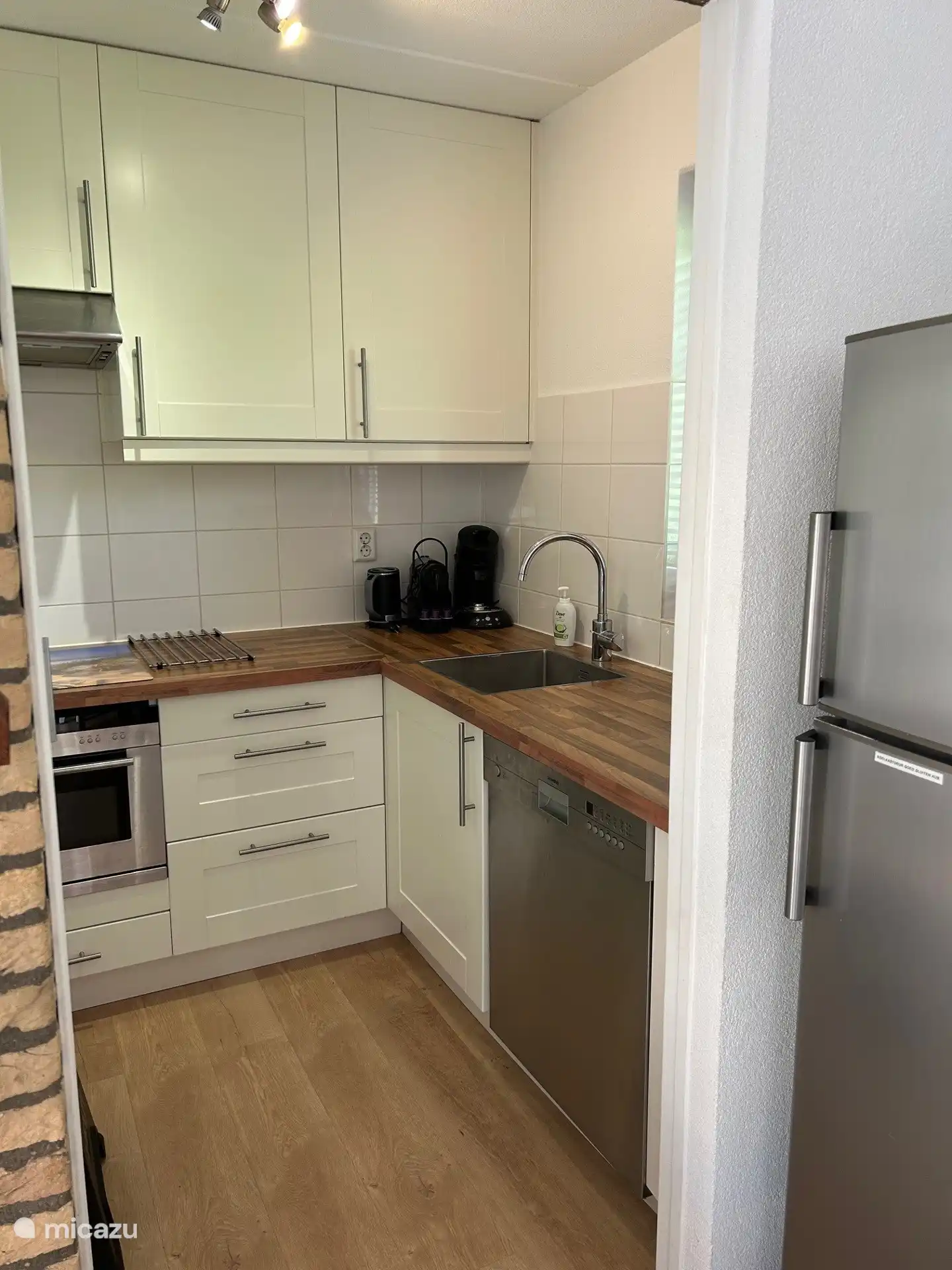 Küche mit Induktionskochfeld, Kombi-Mikrowelle, Geschirrspüler, großem Kühlschrank mit Gefrierfach, Nespresso-Kaffeemaschine, Senseo-Kaffeemaschine und Filterkaffeemaschine, Wasserkocher.