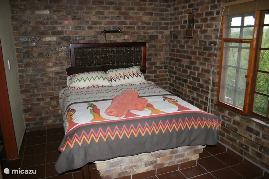 Das Schlafzimmer im Ferienhaus verfügt über einen Ventilator und Klimaanlage.