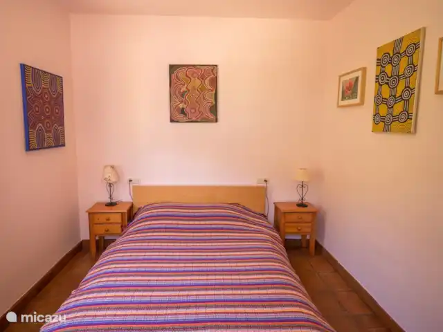 Casa Vallecillo en España, Andalucía, Ronda - casa vacacional Dormitorio con pinturas australianas originales en las paredes.