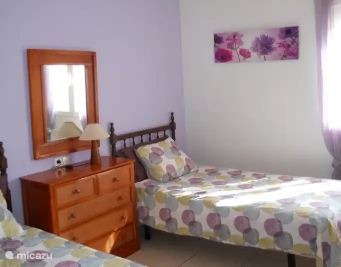 De lila kamer heeft ook voldoende opberg ruimte. Deze kamer is voorzien van een plafondventilator.
Vanuit de kamer heeft u zicht op het zwembad.
De ramen zijn voorzien van horren en rolluiken. 