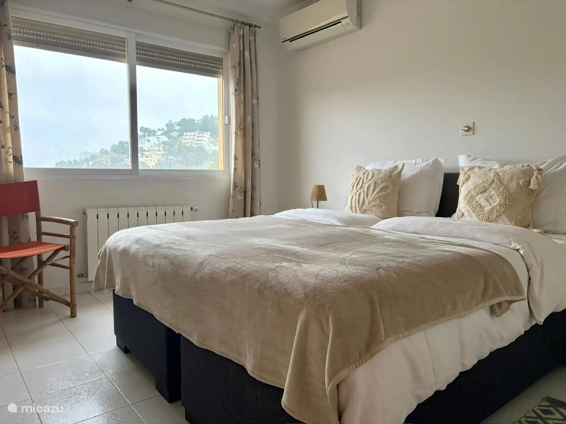 Slaapkamer op tussenverdieping met aangrenzende badkamer .