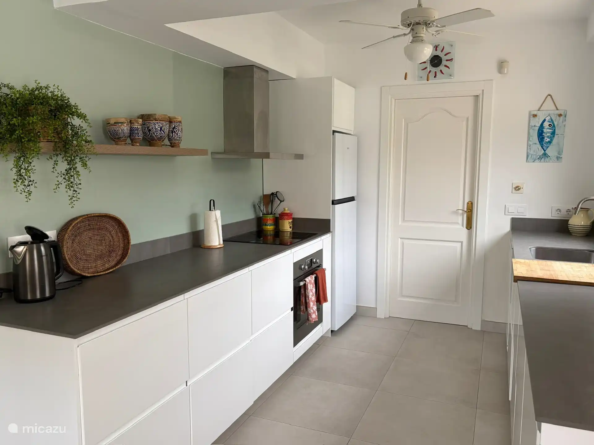 Una cocina completa con lavavajillas, horno, cocina de inducción, lavadora y muchas características.