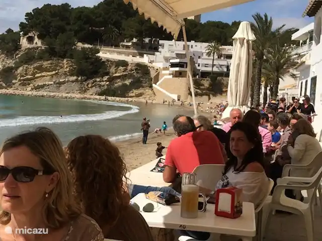 Location de Vacances Espagne, Costa Blanca, Moraira, villa - Casa Lucia La plage intime d’El Portet avec plusieurs terrasses, la location de bateaux et un maître-nageur sur la plage en été.