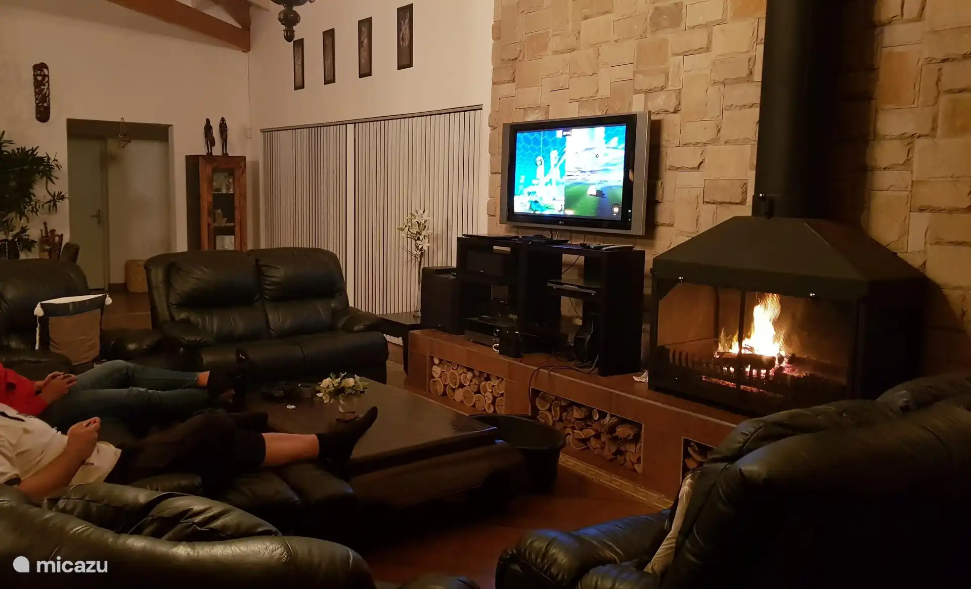In the evening with the fireplace and TV on. 
