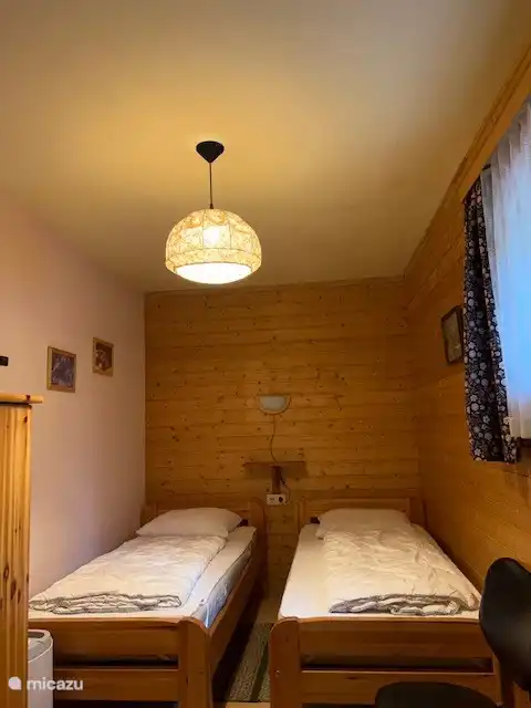Schlafzimmer im Erdgeschoss mit zwei Einzelbetten und Platz für ein Zustellbett.