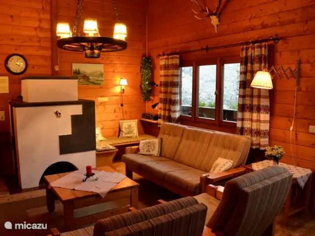 Q-alm | Autriche, Tyrol, Maurach - chalet Le salon cosy de l'étage supérieur avec
un poêle à bois autrichien moderne.