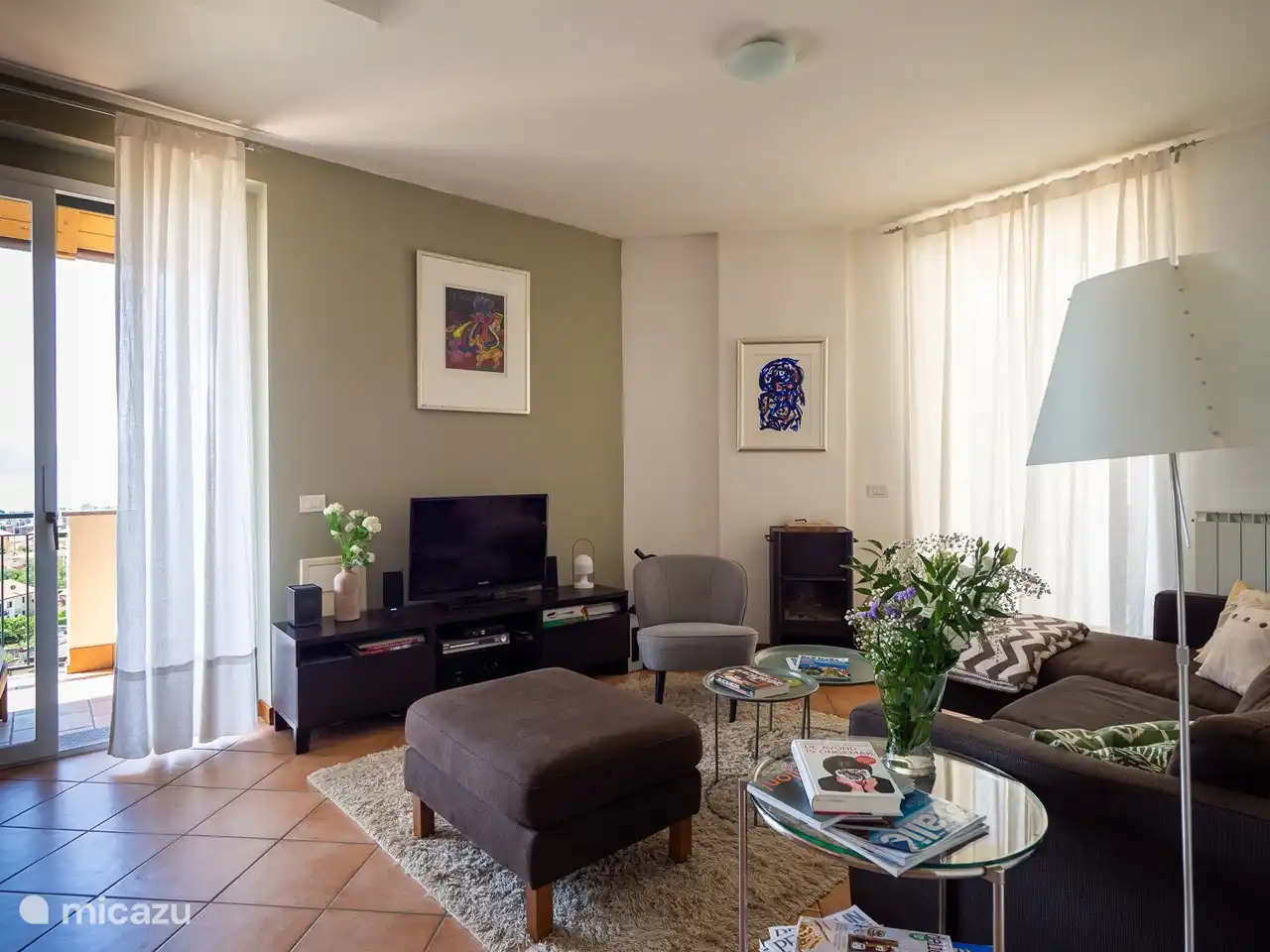 Das Wohnzimmer mit Schiebetüren zur Terrasse auf beiden Seiten