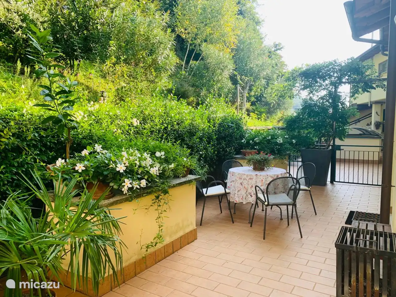 Blick auf die hintere Terrasse. Aufgrund des Schattens ist es hier nachmittags oft schön kühl. Morgens kann man dort in der Sonne frühstücken. Angrenzend an den Berggarten