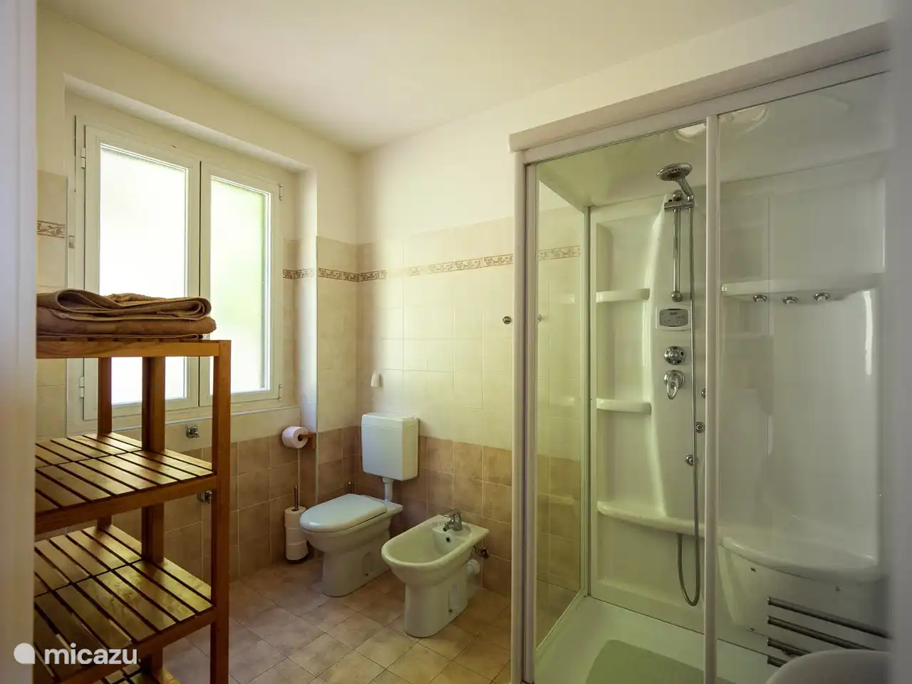 Geräumiges Badezimmer mit Dusche, Waschbecken, WC und Bidet.