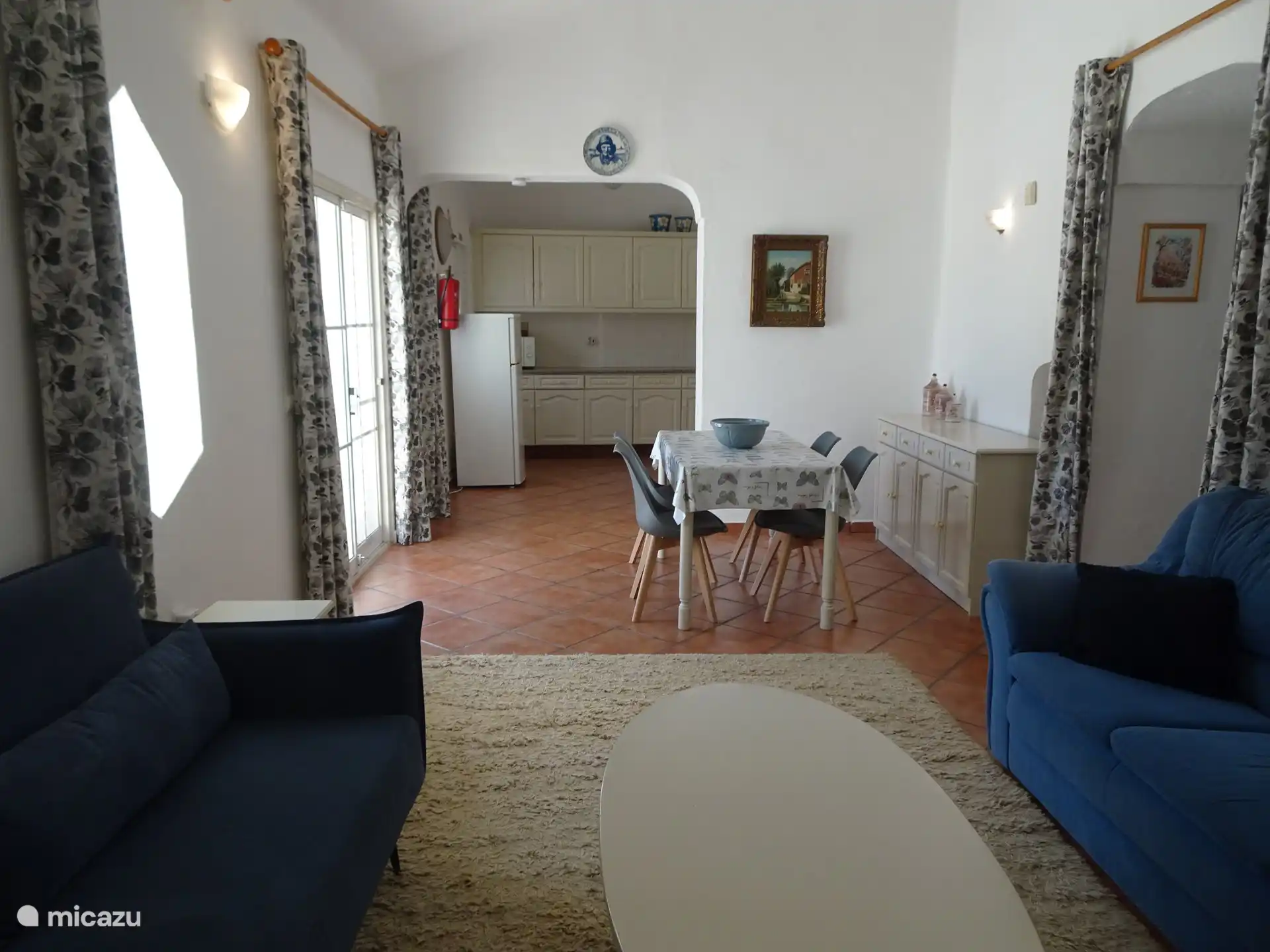 Blick in die Küche mit dem Esstisch davor mit bequemen Schalenstühlen