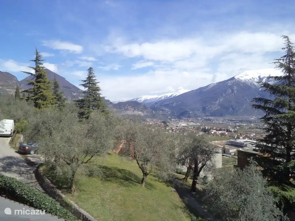 Vue du balcon sur le village d'Arco, Monte Stivo et Monte Bondone. Jardin arboré d'oliviers dans la résidence.