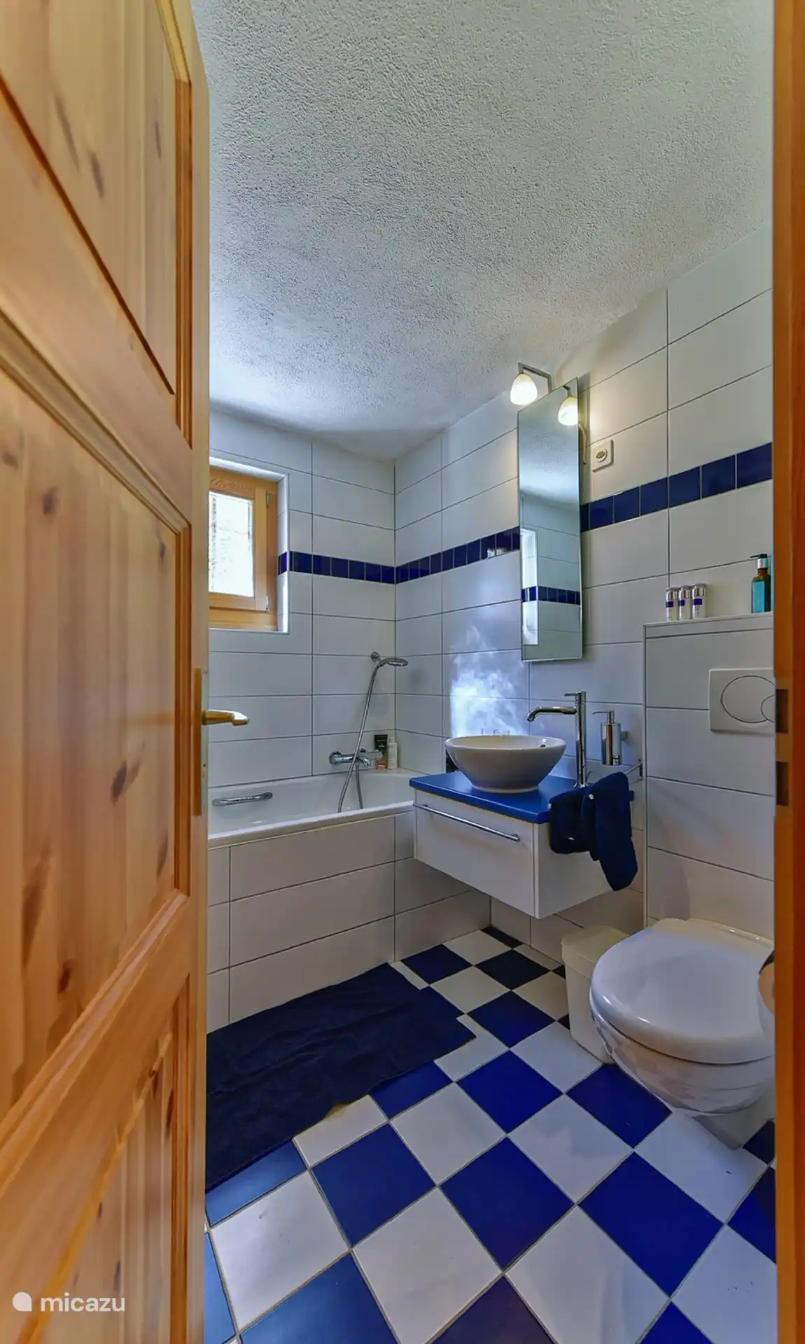 Badkamer met wasbak, bad en aparte douche.