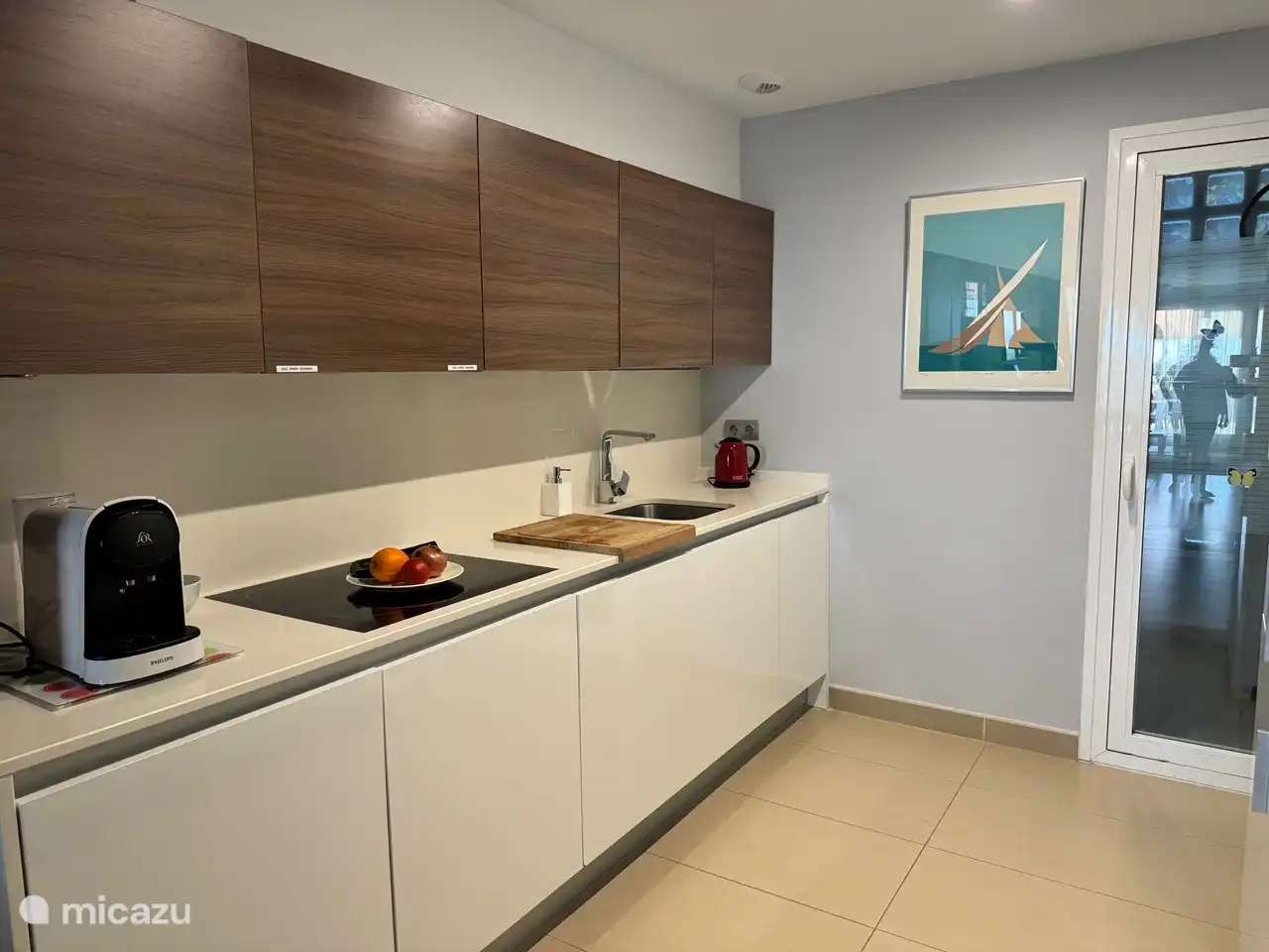 Cuisine avec plaques de cuisson, hotte aspirante, lave-vaisselle, four, réfrigérateur/congélateur et micro-ondes.