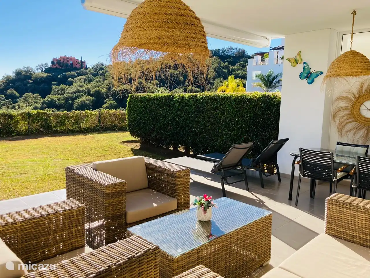 Terrasse avec salon, transats et coin repas.