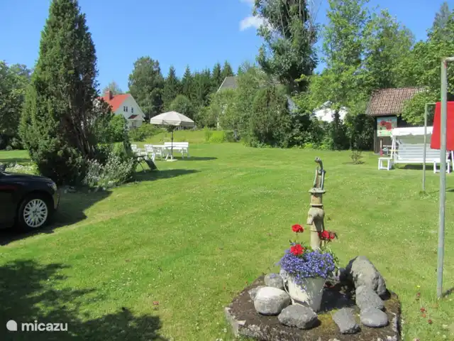 La casa Blanca en Suecia, Västergötland, Vegby - casa vacacional Jardín con columpio y muebles de jardín.
