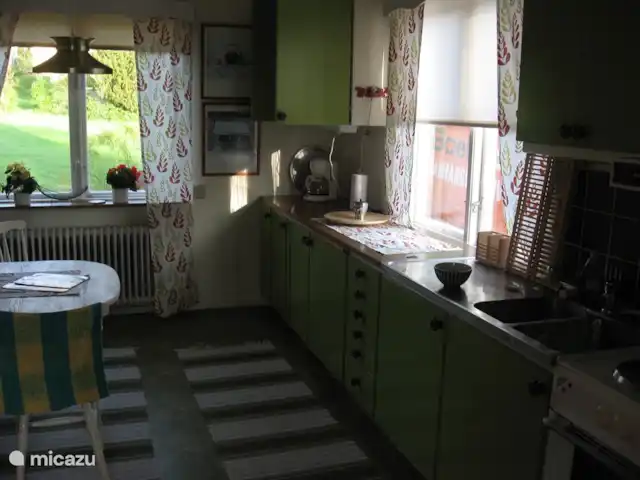La casa Blanca en Suecia, Västergötland, Vegby - casa vacacional Acogedora cocina con vista al jardín y posibilidad de desayunar con cuatro personas en la mesa.