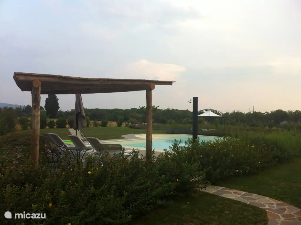 Hermosa piscina con techo, ducha al aire libre y baño separado con inodoro en la piscina.