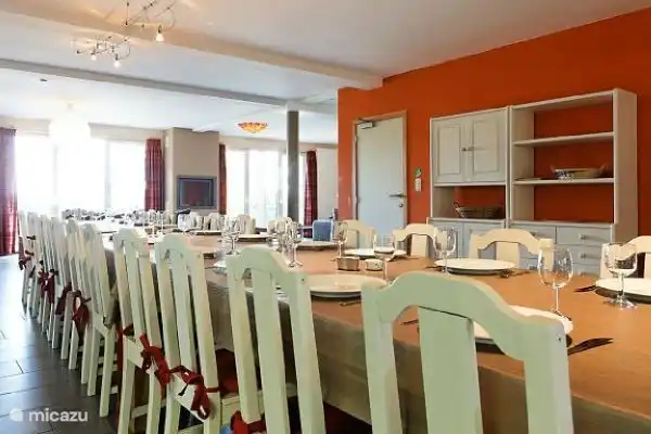 El amplio comedor para 24 personas con chimenea invita a disfrutar de una comida acogedora