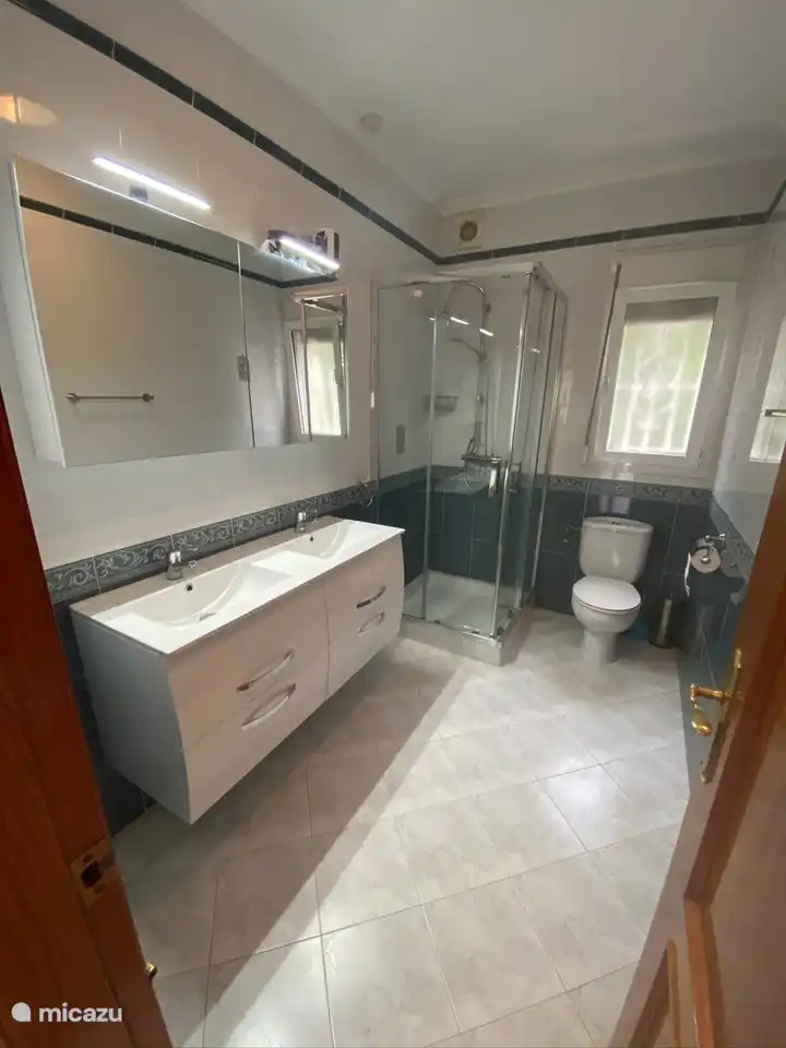 El baño con doble lavabo, ducha y WC.