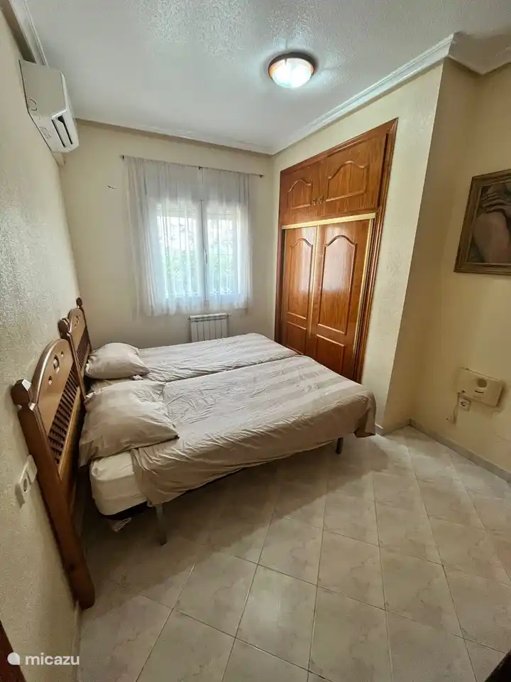 Dormitorio más pequeño con armarios empotrados.