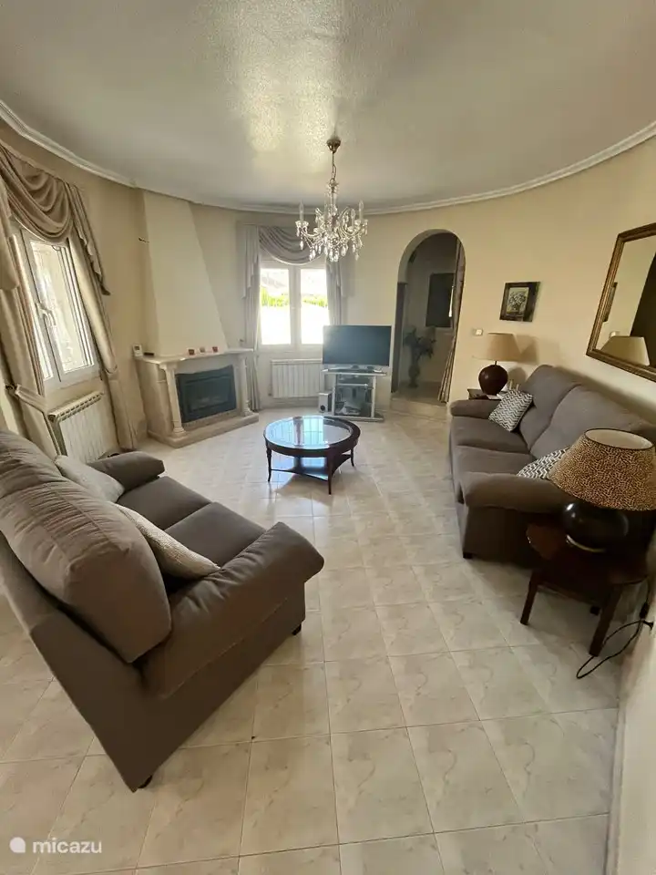 Salón con sofá de 2+3 plazas, TV y chimenea de gas.