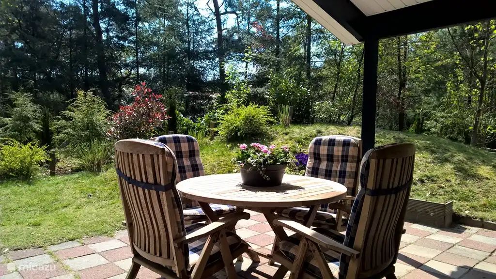 Schöne private Terrasse mit Gartenmöbeln aus Teakholz und Blick auf den schönen Waldgarten.