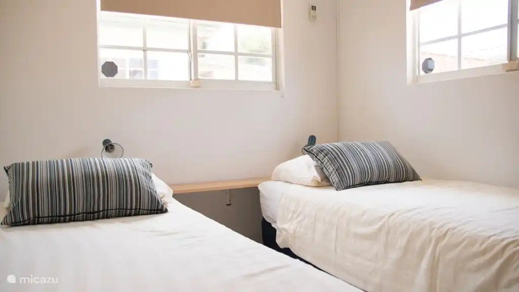 El segundo dormitorio tiene dos camas individuales, que se pueden convertir fácilmente en una cama doble. Esta habitación también tiene un amplio armario, aire acondicionado y baño privado.