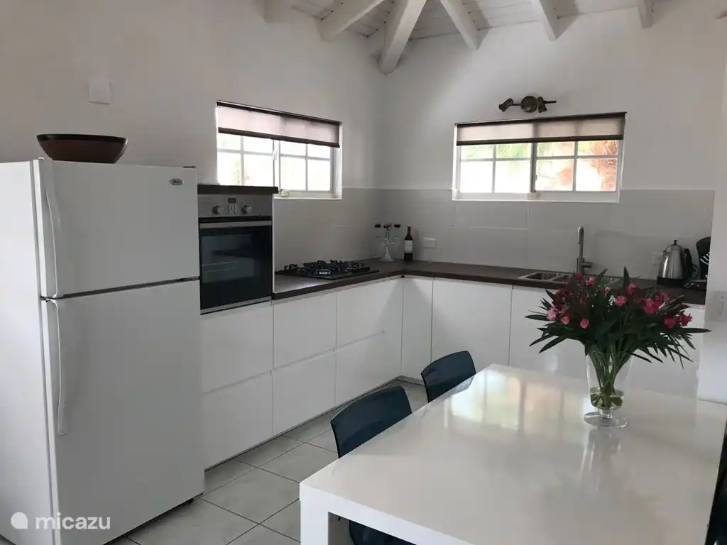 La cocina esquinera está equipada con nevera, horno, vitrocerámica y lavavajillas.