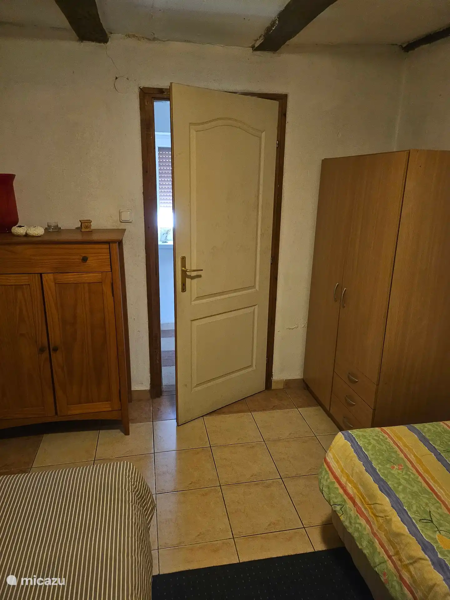 Kinderzimmer mit dem Kleiderschrank mit Bettwäsche auf der linken Seite und dem Kleiderschrank auf der rechten Seite