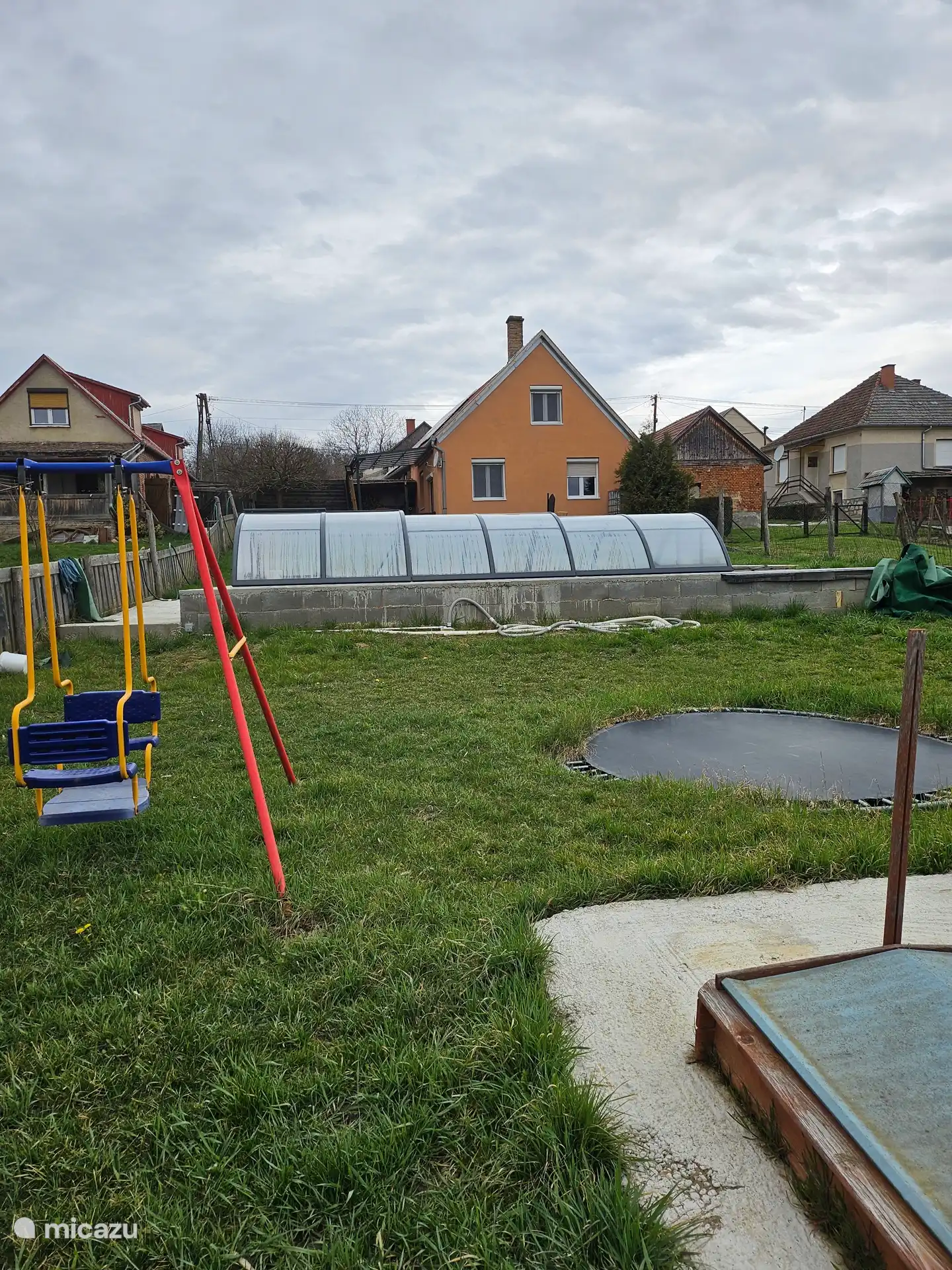 Garten mit Zuja, Schaukeltrampolin, Fußballtoren und Basketballkorb sowie extra Sitzbereich über dem Pool.