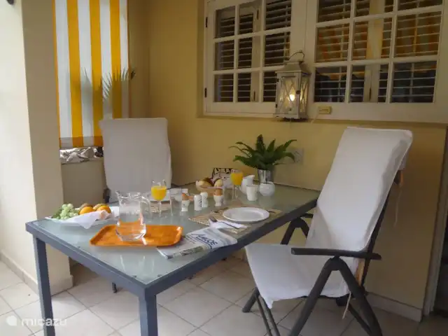Dushipalm en Curazao, Curazao Centro, Piscadera - apartamento Mesa de comedor en el balcón trasero, al lado de la cocina, para un desayuno temprano y soleado.
